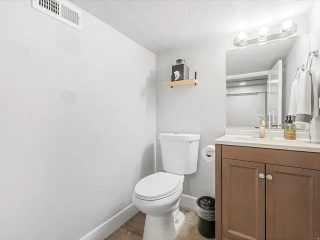Bathroom featuring a vanity with brown wood-finish cabinetry, a white countertop, and a rectangular sink