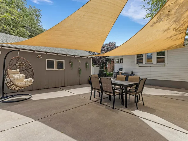 Expansive concrete patio area with two large overhead shade sails