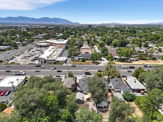 Expansive urban landscape featuring a multi-lane roadway, commercial buildings, and residential properties