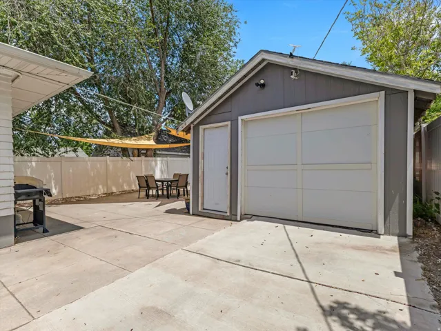 Detached garage with a paneled door and a separate entry door