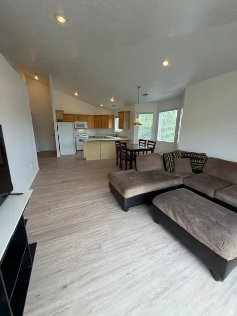 Open-concept living area with vaulted ceilings, recessed lighting, brnd new LVP floors & fresh paint thru-out!