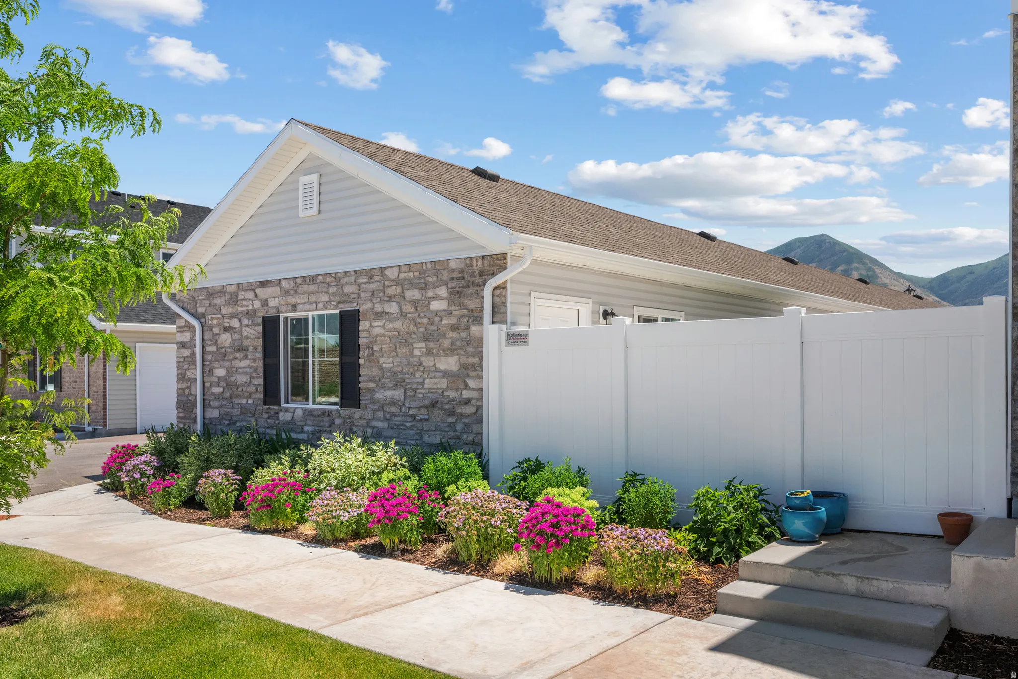 Stone and siding exterior with a pitched roof and visible mountain backdrop