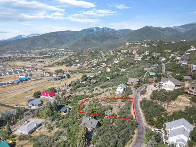 Elevated lot featuring natural vegetation, a paved road, and mountain scenery