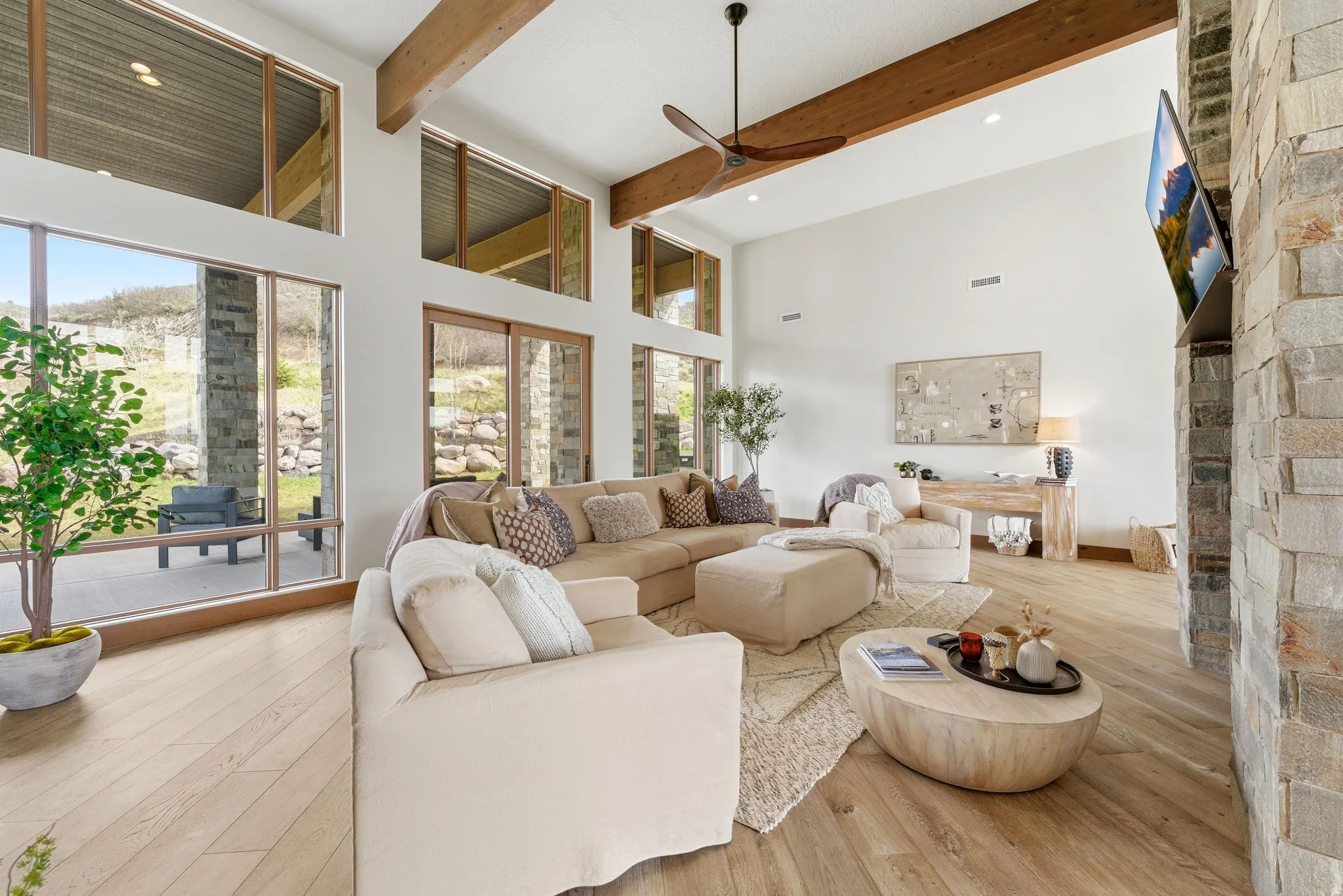 Two-story living area featuring wood-finish flooring and a stone accent wall