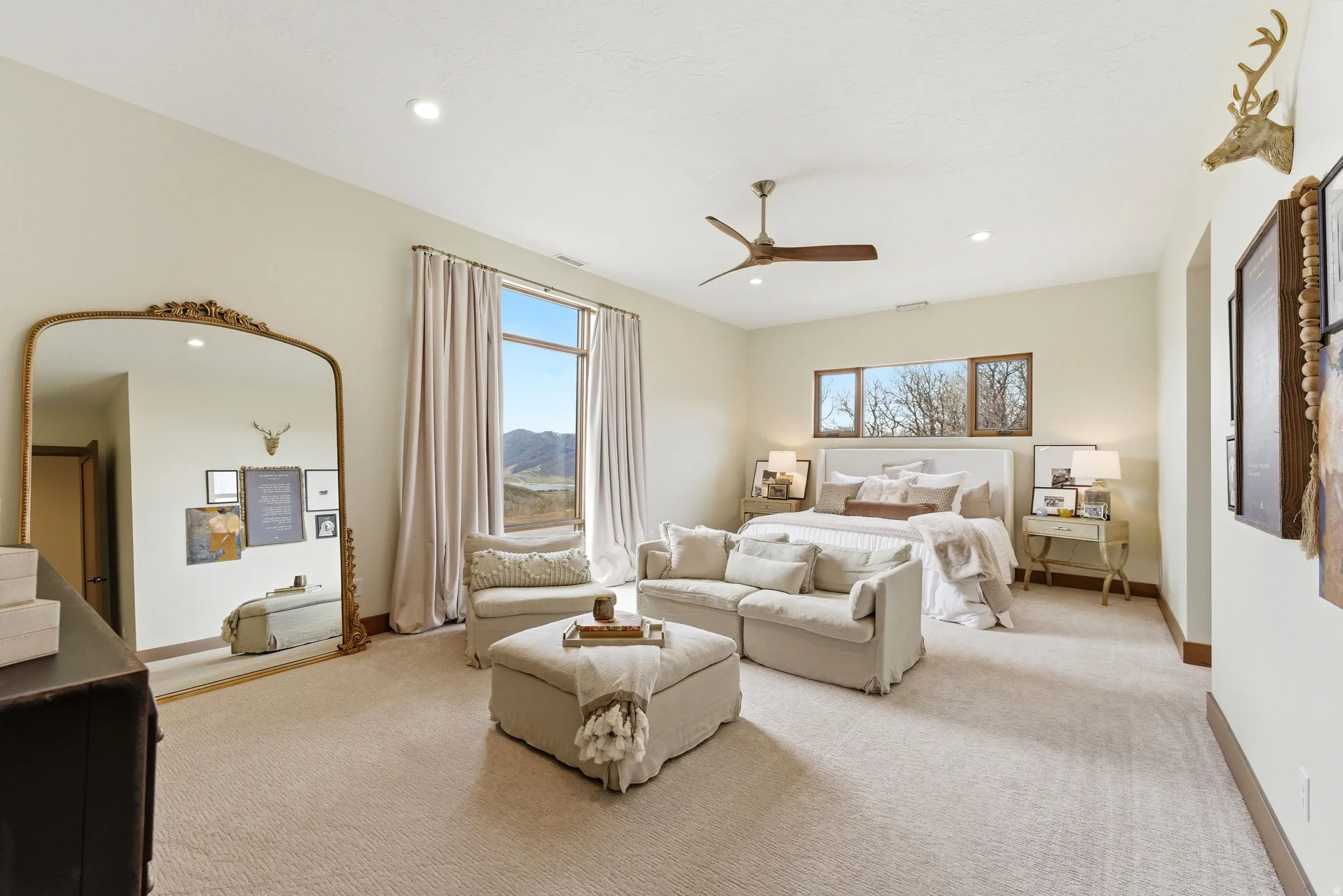 Spacious bedroom featuring neutral carpeting, a high ceiling with recessed lighting, and a ceiling fan