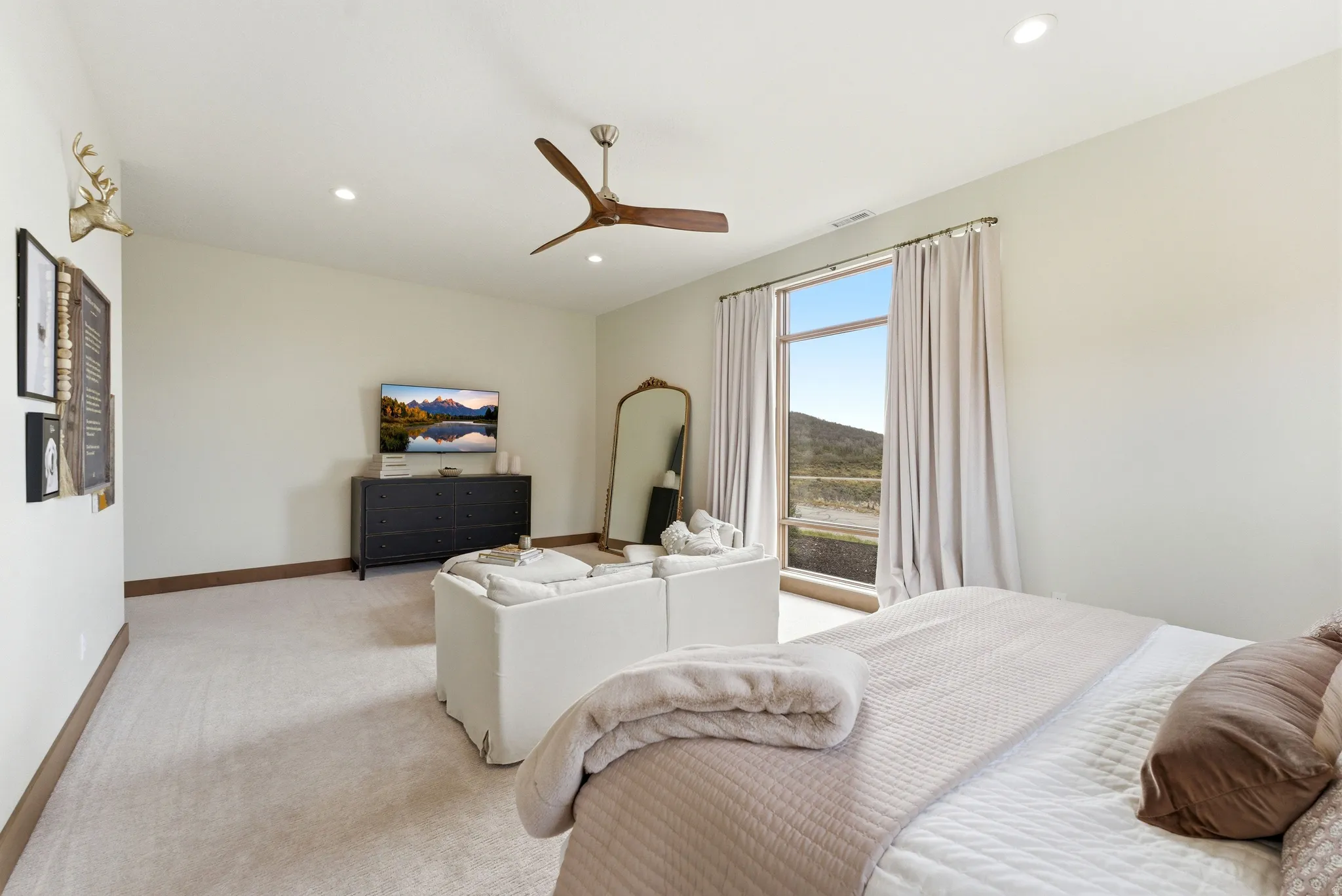 Expansive room with large picture window, recessed lighting, and a modern ceiling fan