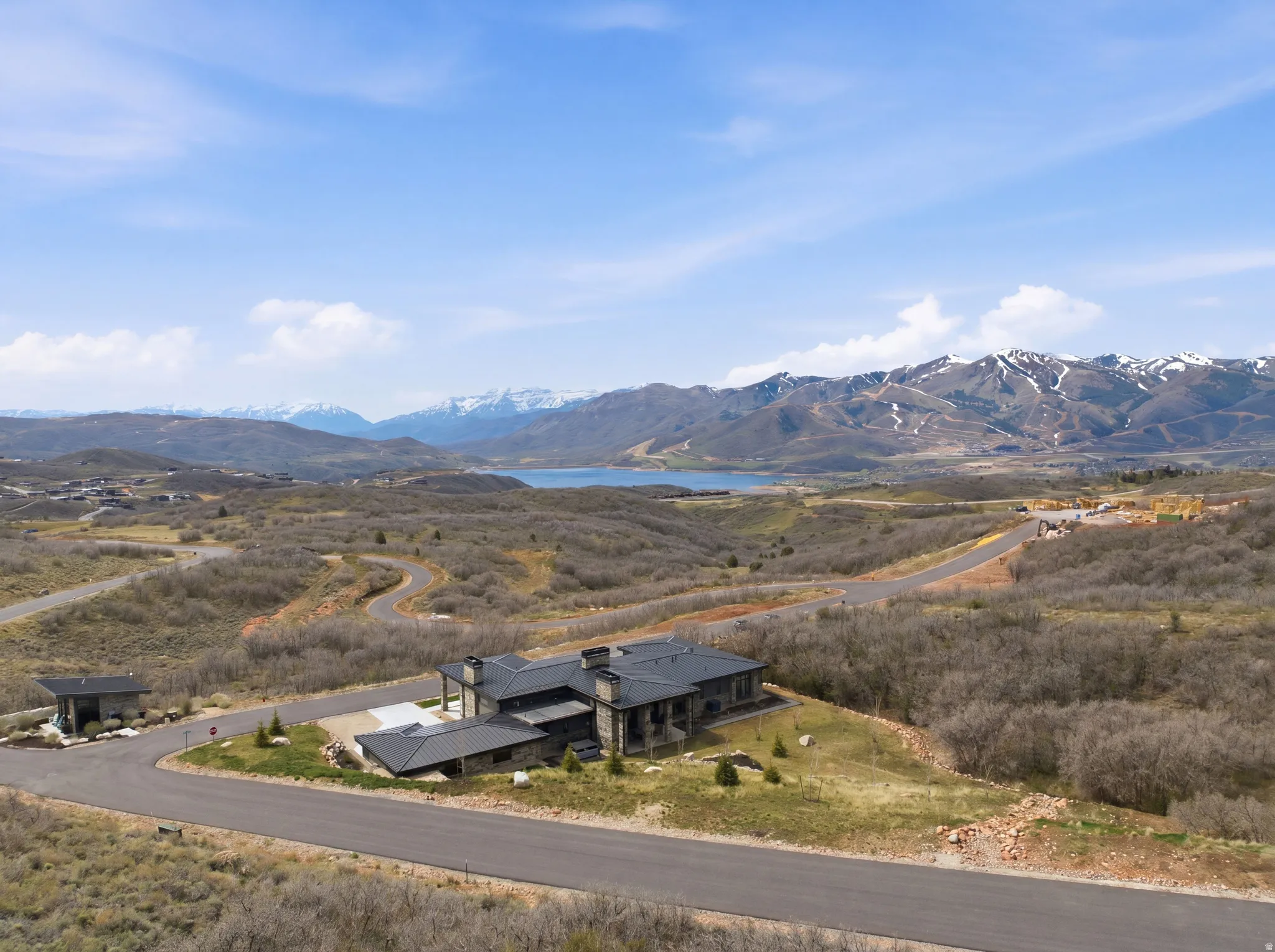 Sprawling estate featuring extensive stone siding, multiple rooflines, and a paved driveway