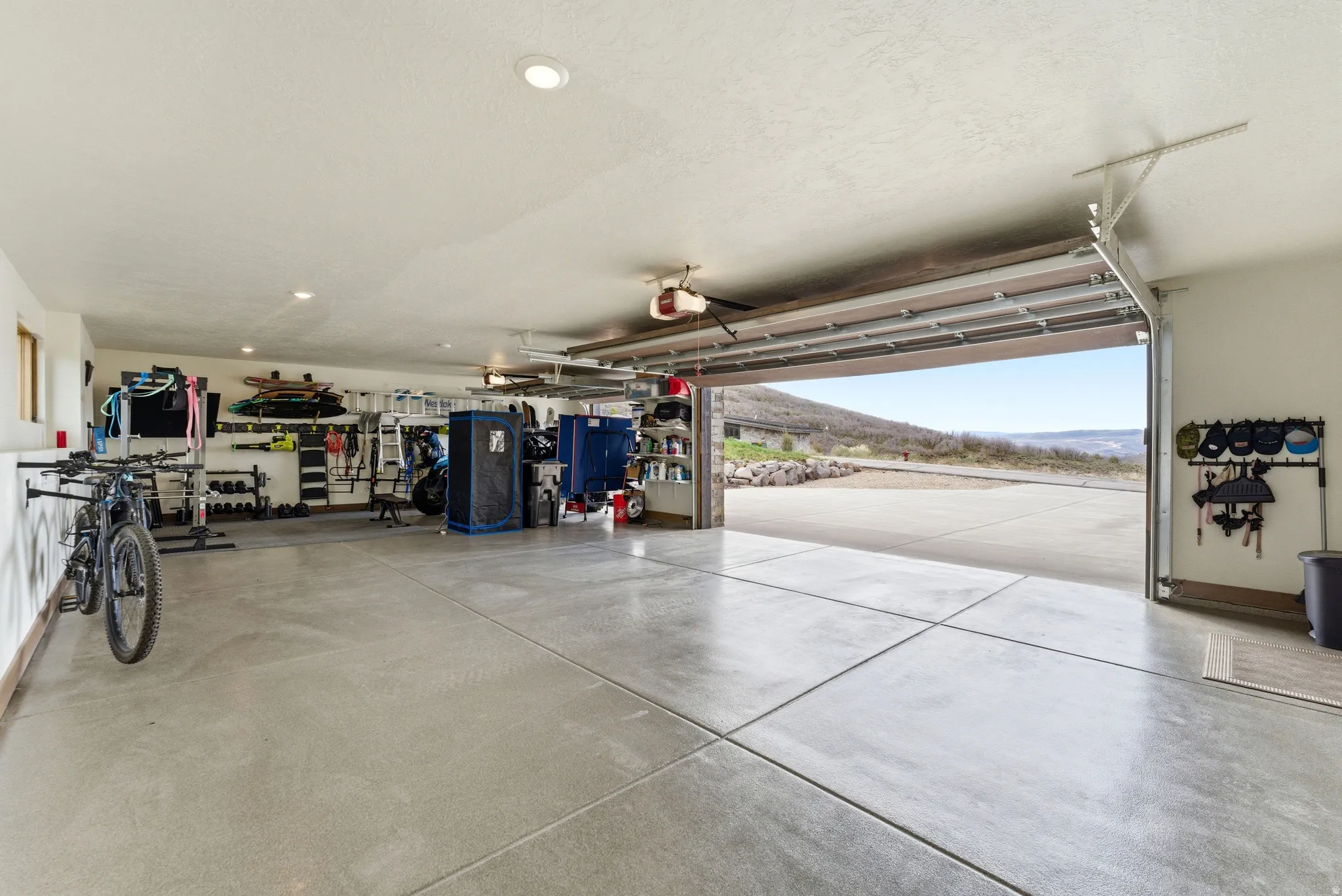 Spacious garage featuring concrete flooring, recessed lighting, and an overhead garage door