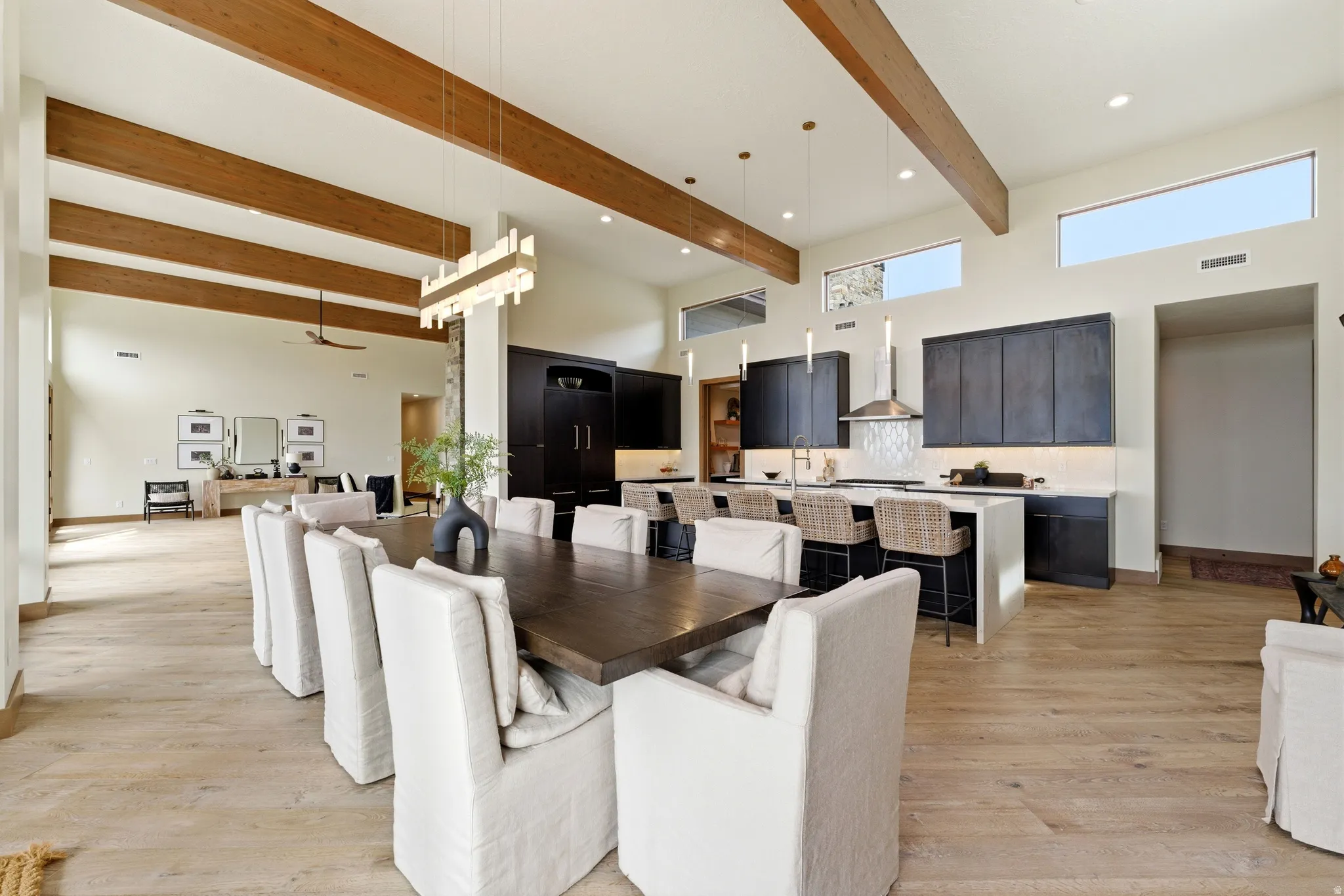 Spacious open-concept interior featuring high vaulted ceilings with exposed wood beams