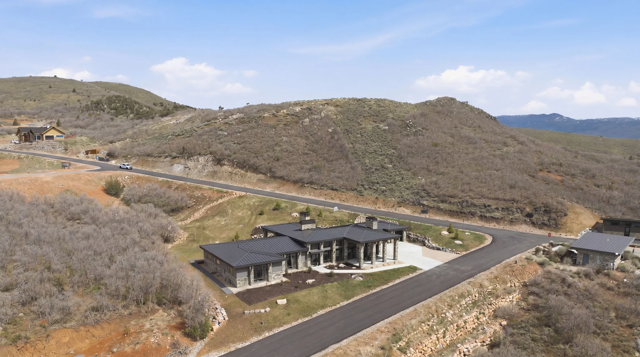 Contemporary architectural residence with a dark metal roof and stone facade