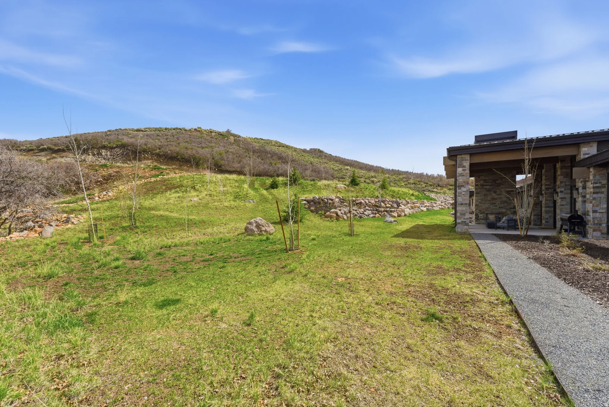 Expansive natural landscape with a gravel pathway leading to a covered patio