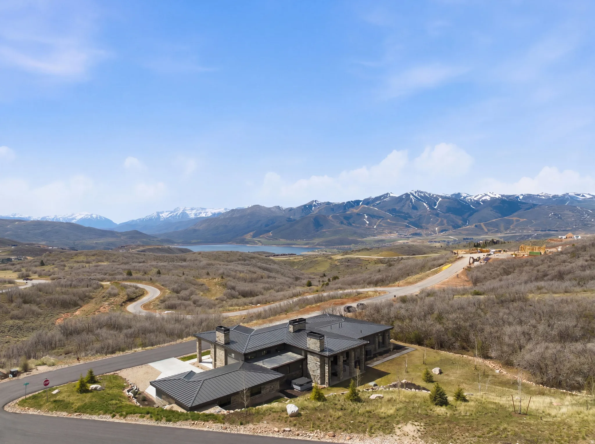 Modern mountain residence featuring a durable metal roof, stone exterior accents, and an integrated garage