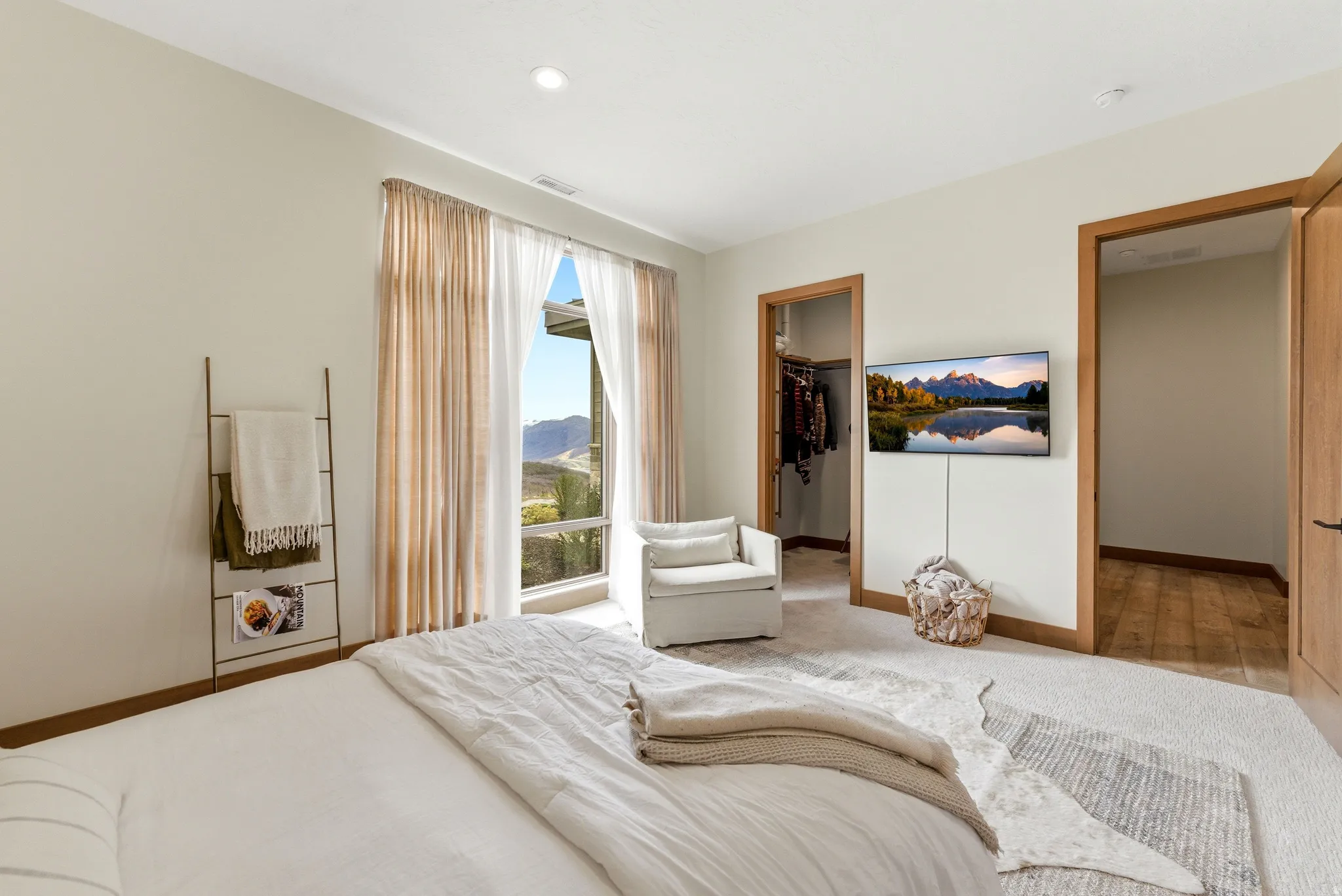 Room featuring a large window with mountain scenery, recessed lighting, and a wall-mounted display
