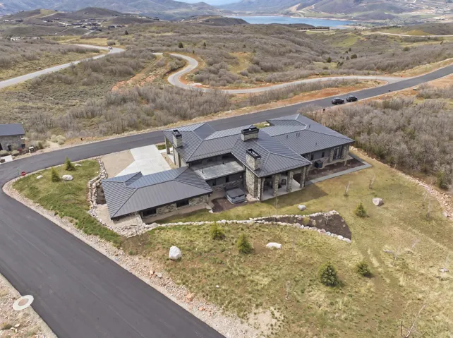 Expansive stone exterior residence with a dark metal standing seam roof
