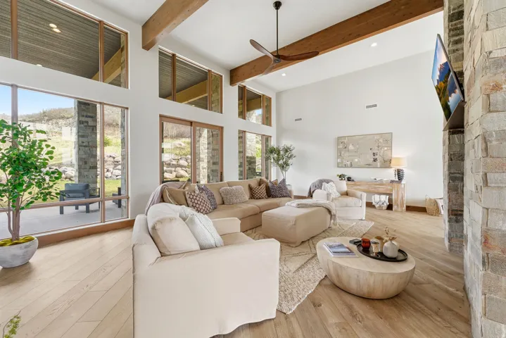 Two-story living area featuring wood-finish flooring and a stone accent wall