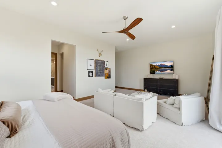 Recessed lighting throughout, wood-finish ceiling fan, and light-colored carpet flooring