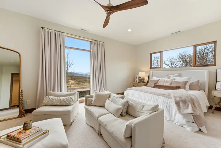Spacious bedroom featuring a full-height window, two transom windows, recessed lighting, and a ceiling fan with wood-finish blades