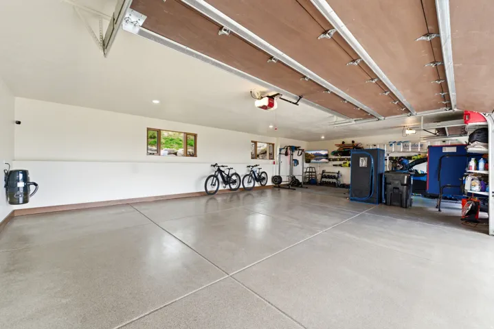 Spacious two-car garage featuring a light gray epoxy floor and two automatic garage doors