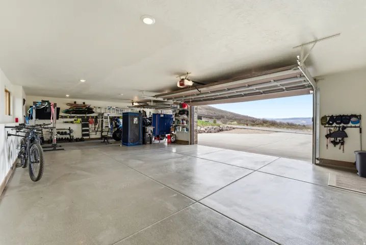Spacious garage featuring concrete flooring, recessed lighting, and an overhead garage door