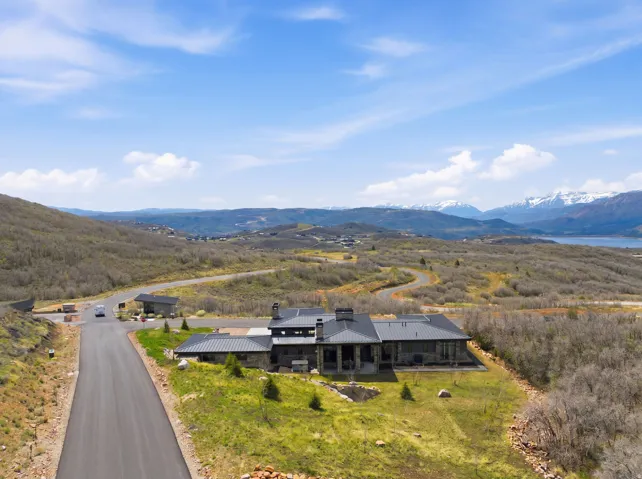 Modern residence featuring a dark stone exterior and a metal roof