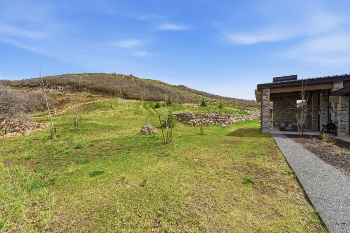 Expansive natural landscape with a gravel pathway leading to a covered patio
