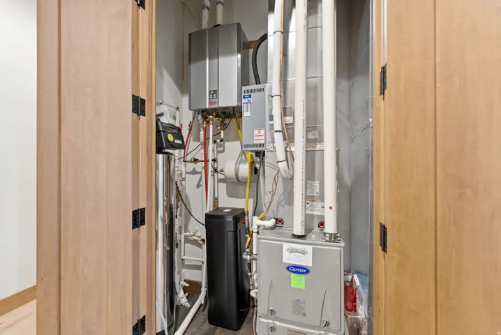 Utility closet featuring a water heater, furnace, water softener, and water filtration system