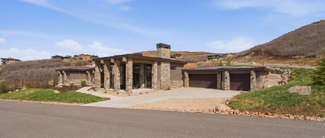 Contemporary facade featuring extensive stone cladding and a prominent stone chimney