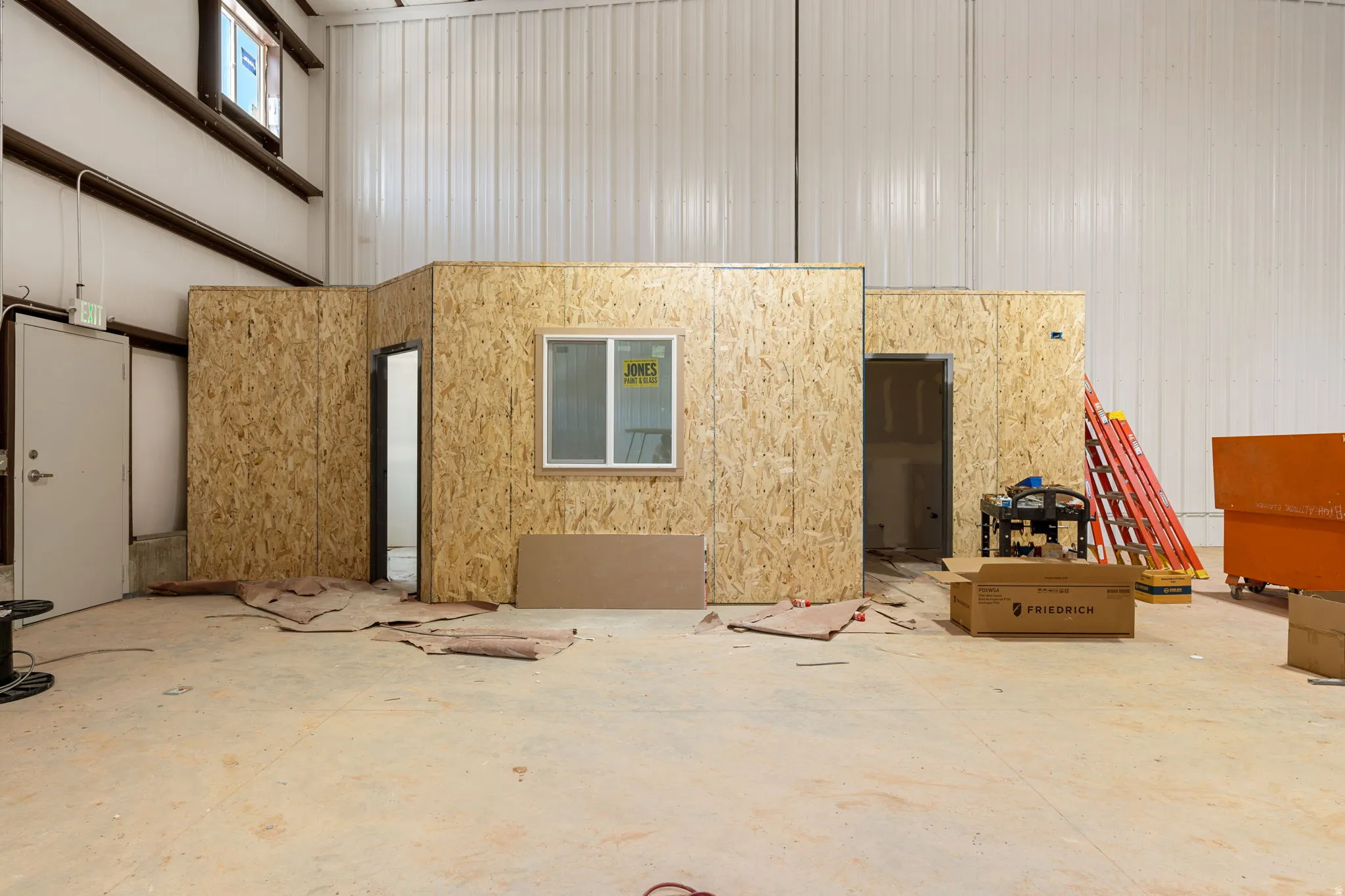 Spacious industrial interior featuring high ceilings and concrete flooring