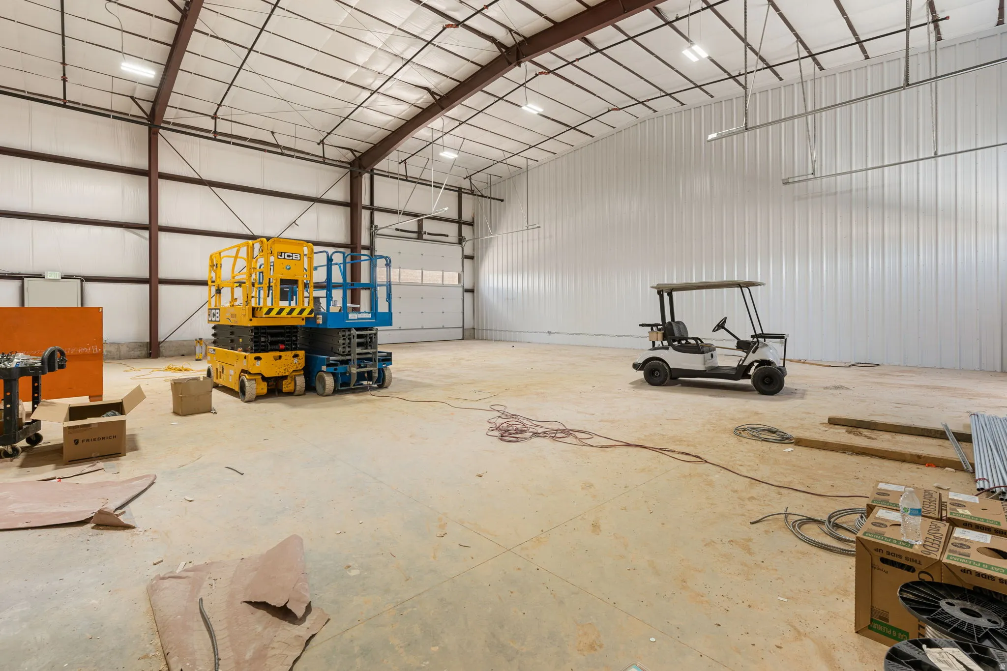 Spacious industrial interior featuring a high arched ceiling with exposed metal trusses