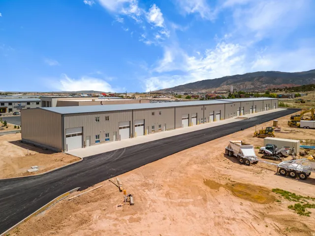 Industrial complex featuring multiple bays with roll-up doors, loading docks, and metal siding