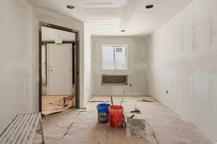 Interior space with drywall installation complete, featuring recessed ceiling lighting