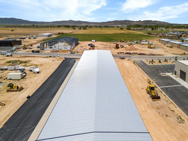 Corrugated metal roofing structure with asphalt paving