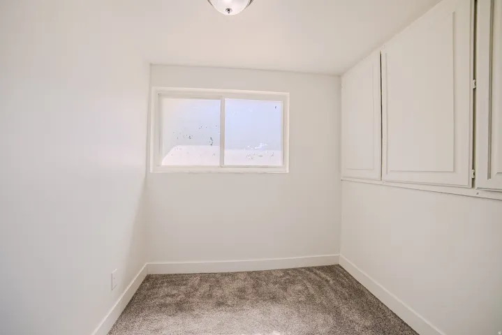 White walls complement the grey carpet flooring