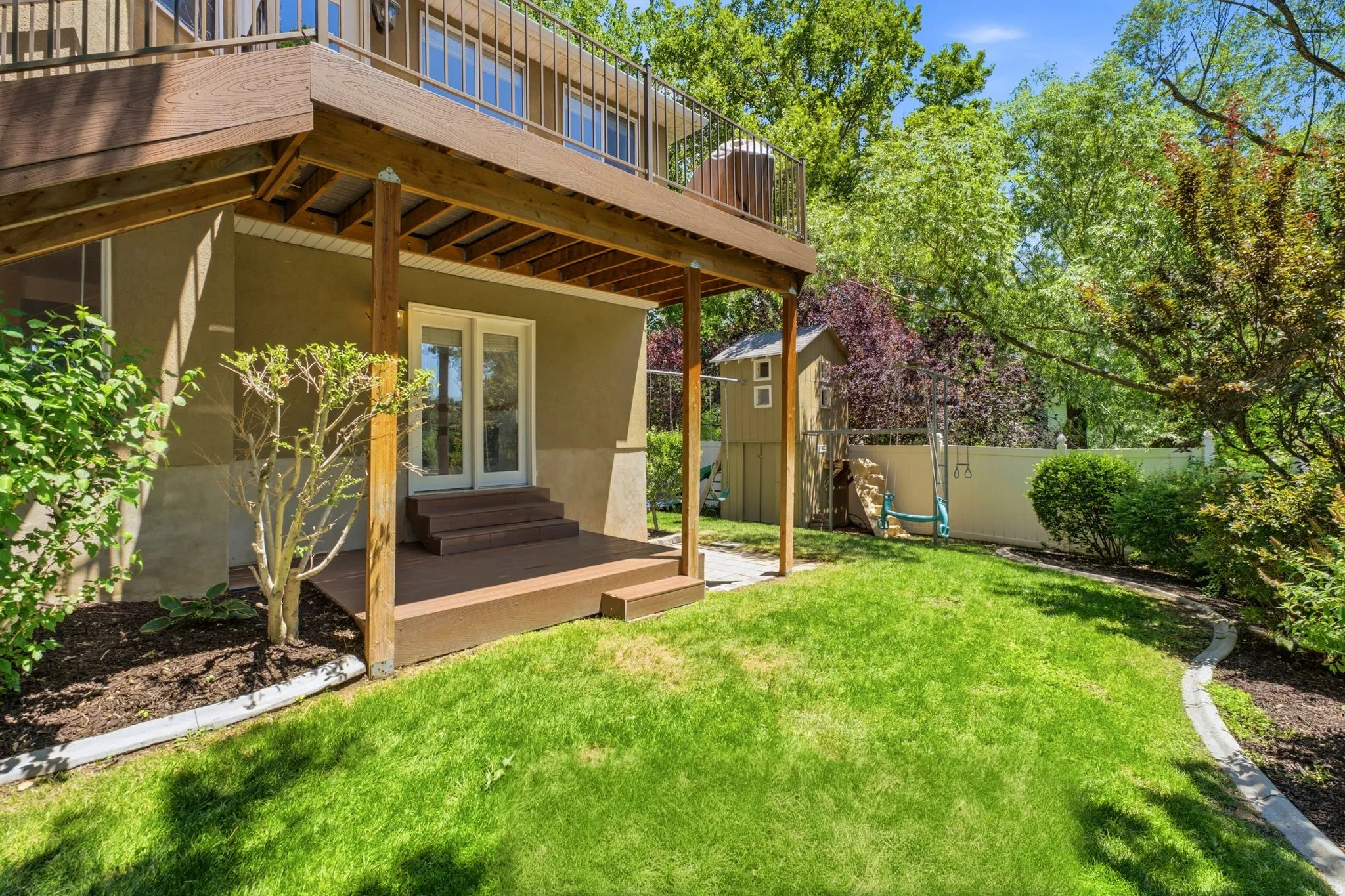 Expansive backyard featuring a manicured lawn and mature trees