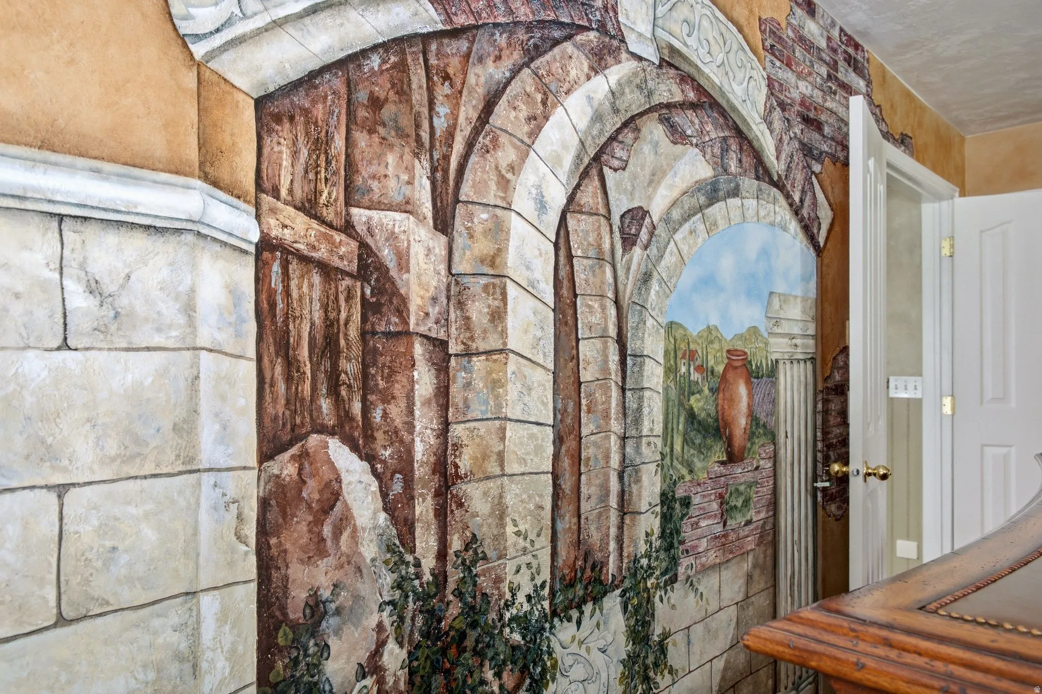 Custom wall mural featuring arched architectural elements and a painted landscape