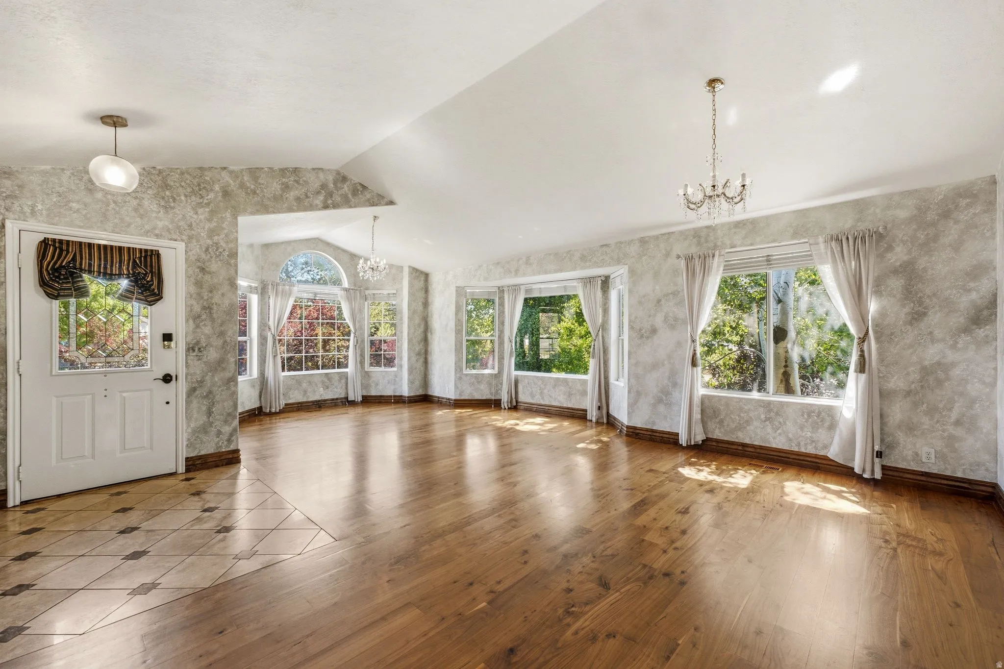 Expansive living area featuring wood-finish flooring and a vaulted ceiling