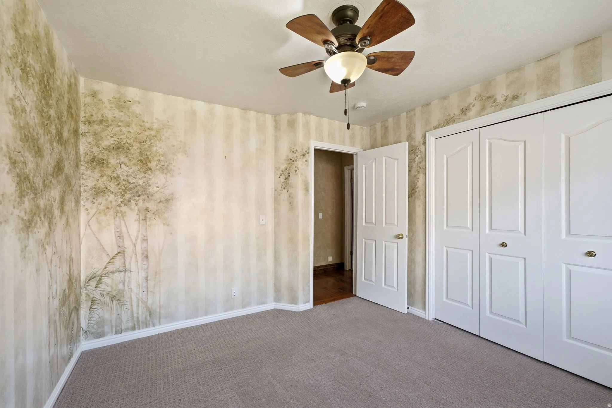 Interior room featuring broadloom carpeting and walls with a nature-inspired mural