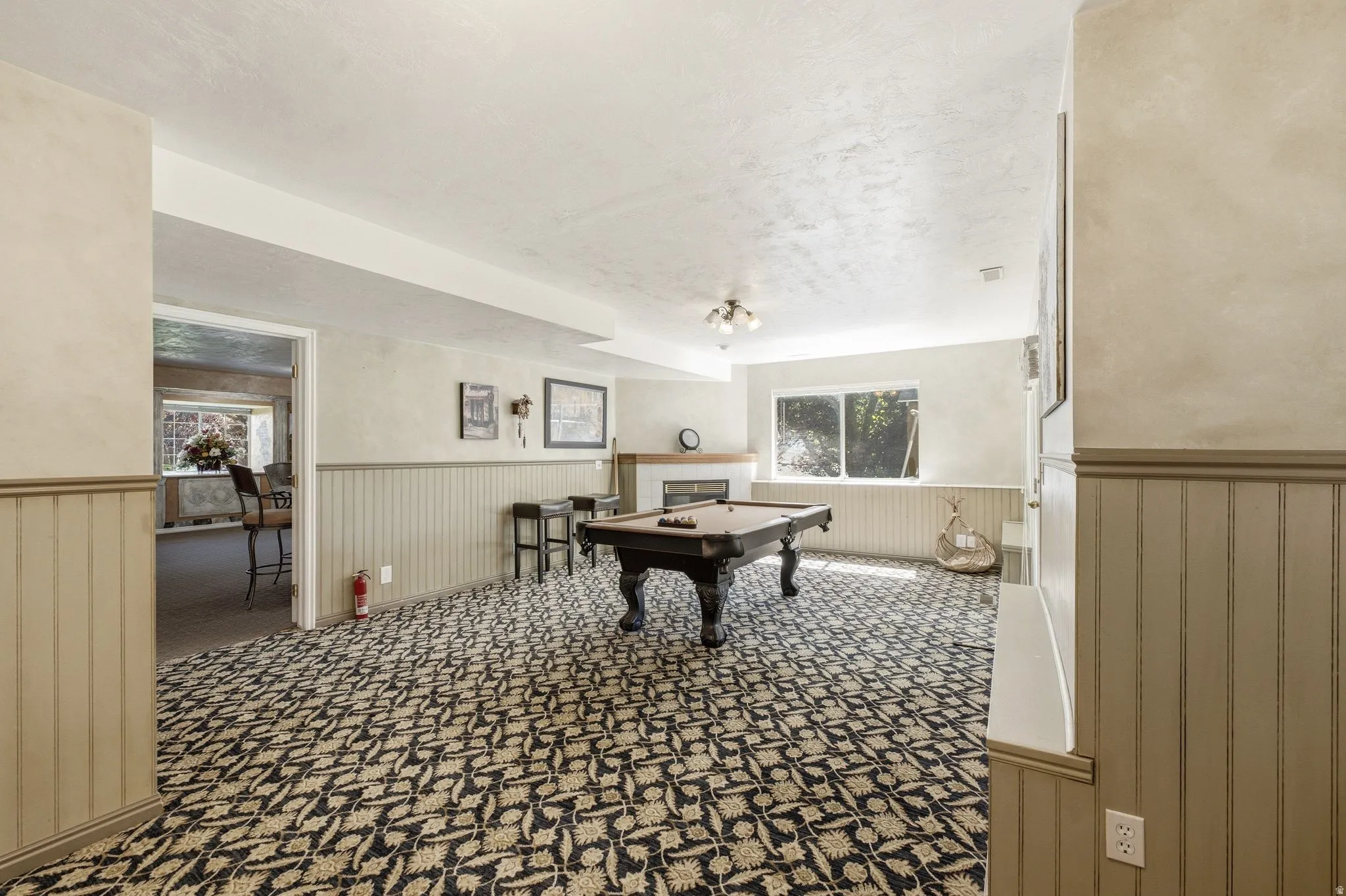 Spacious room featuring patterned carpet flooring and wainscoting