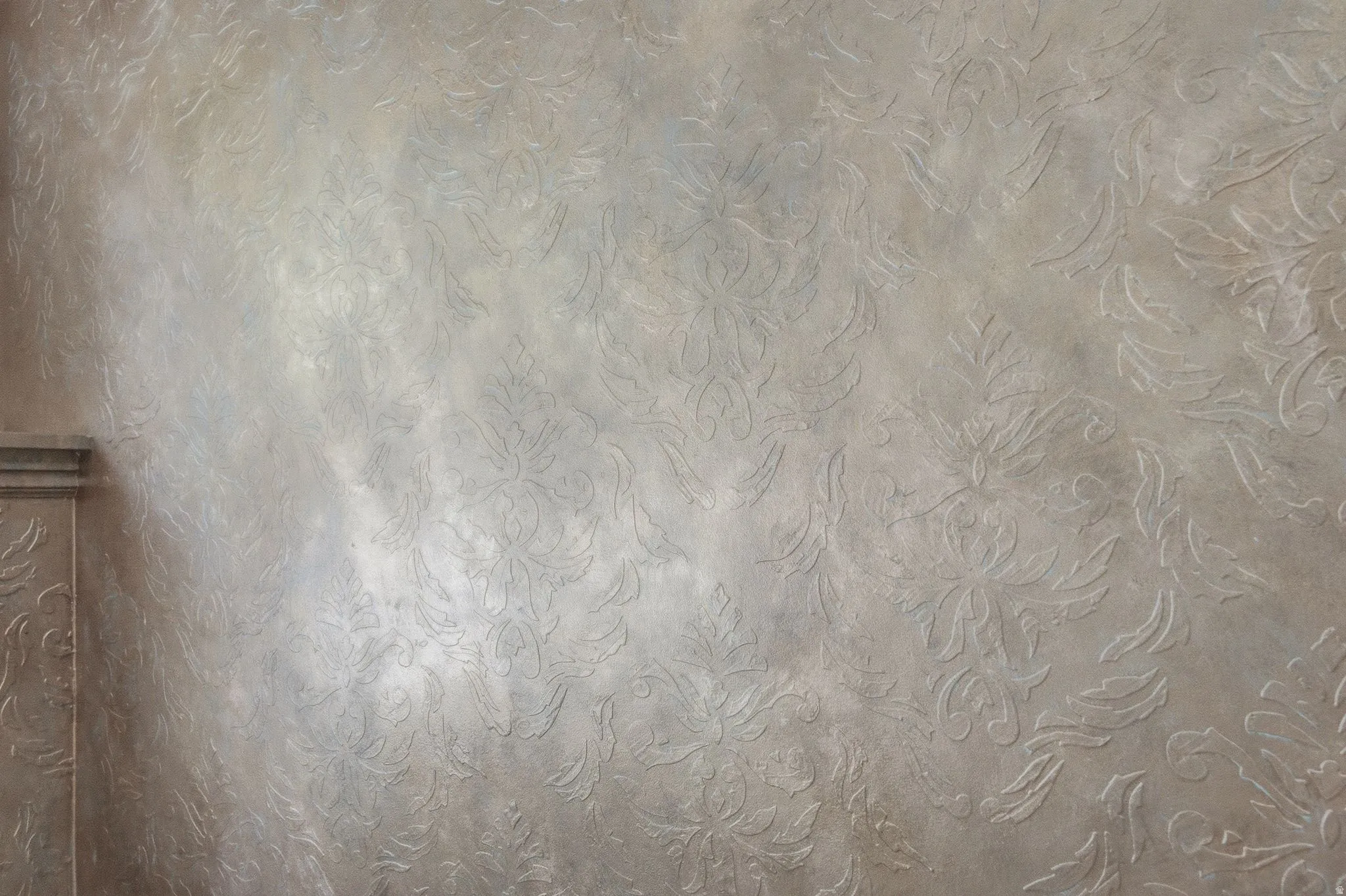 Textured wall finish with a prominent damask pattern
