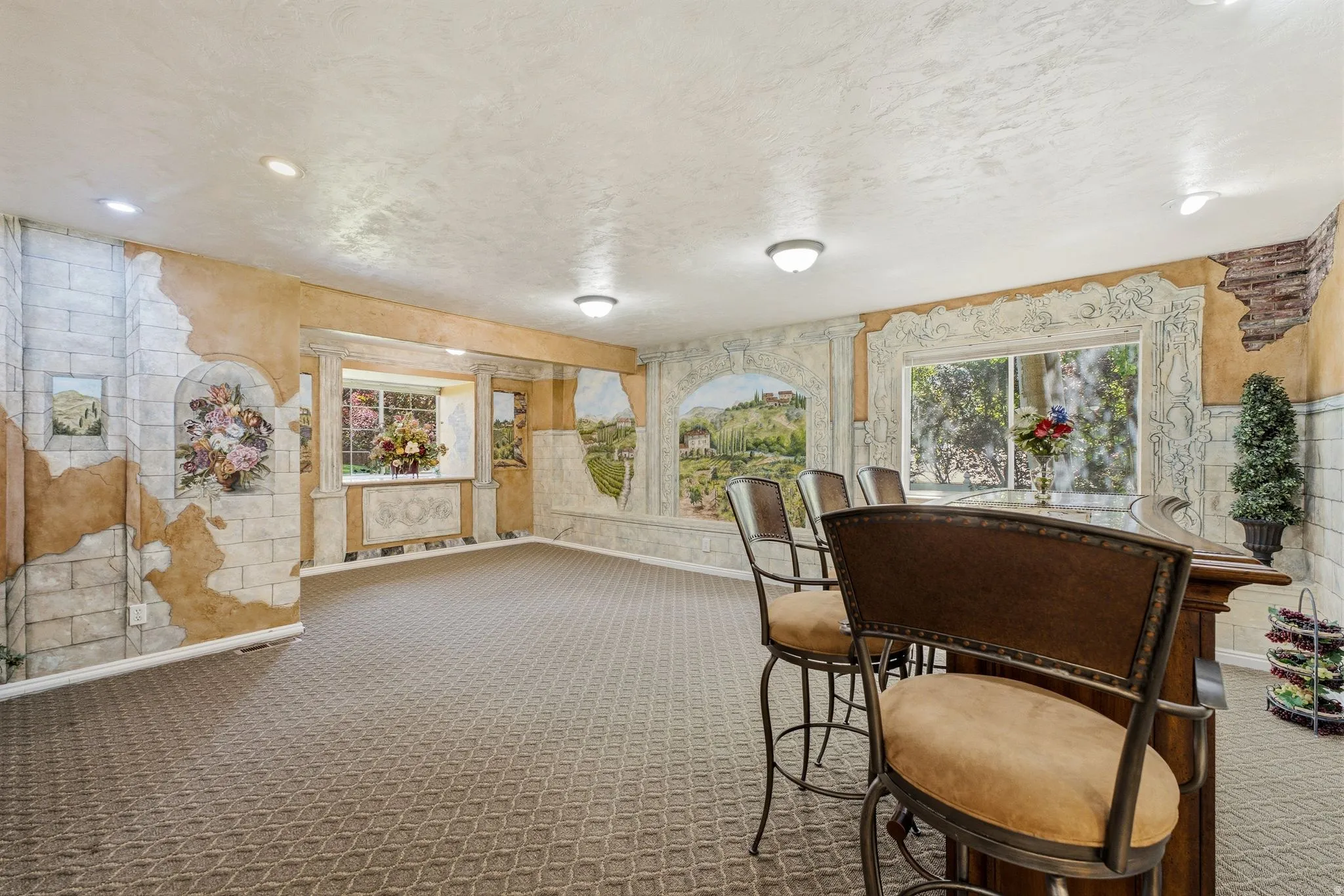 Spacious room with a built-in bar featuring a dark wood-finish countertop and seating for four