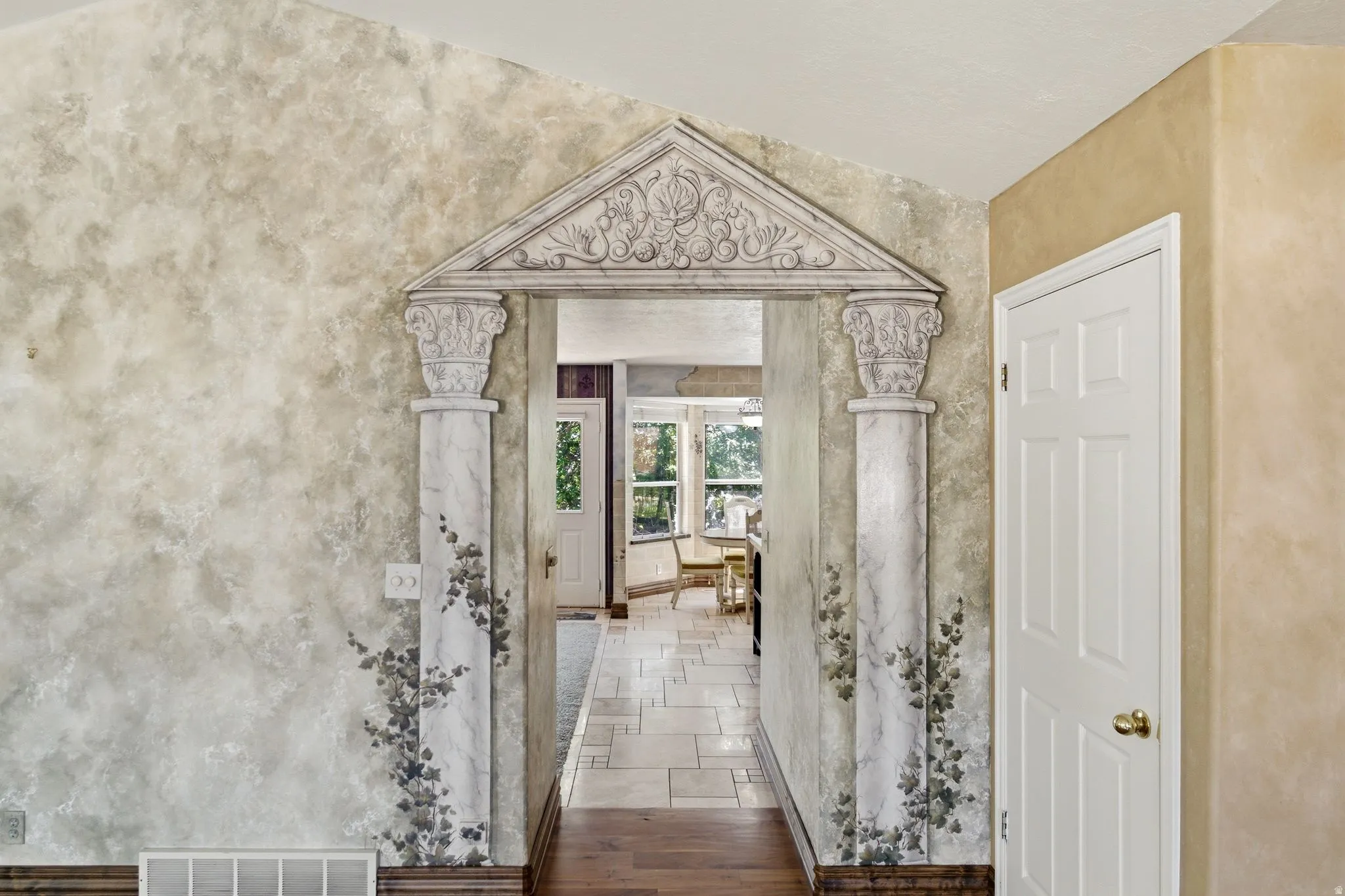 Decorative archway featuring a pediment design with ornate carvings and fluted columns