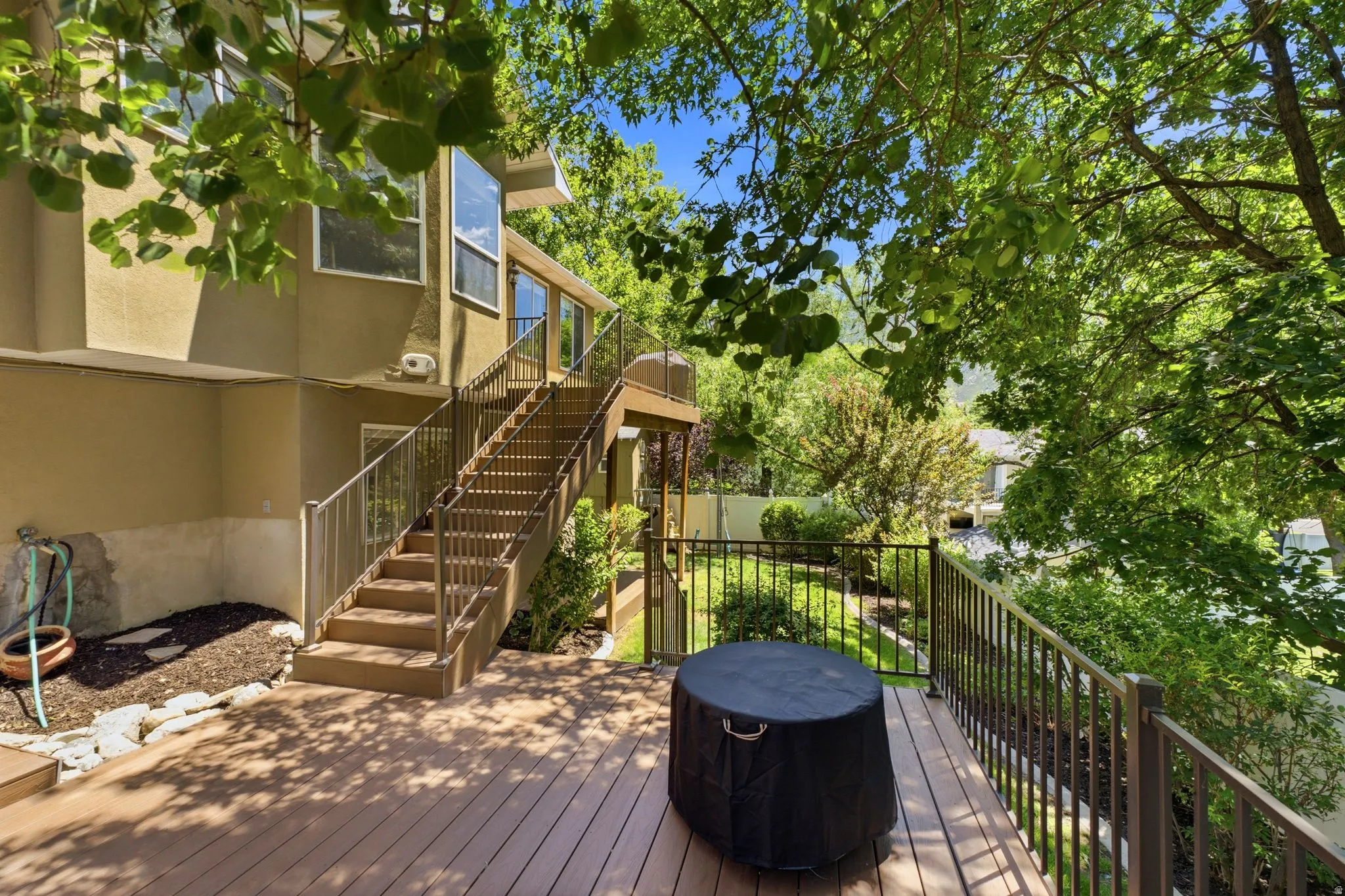 Spacious multi-level deck featuring wood-finish decking and metal railings