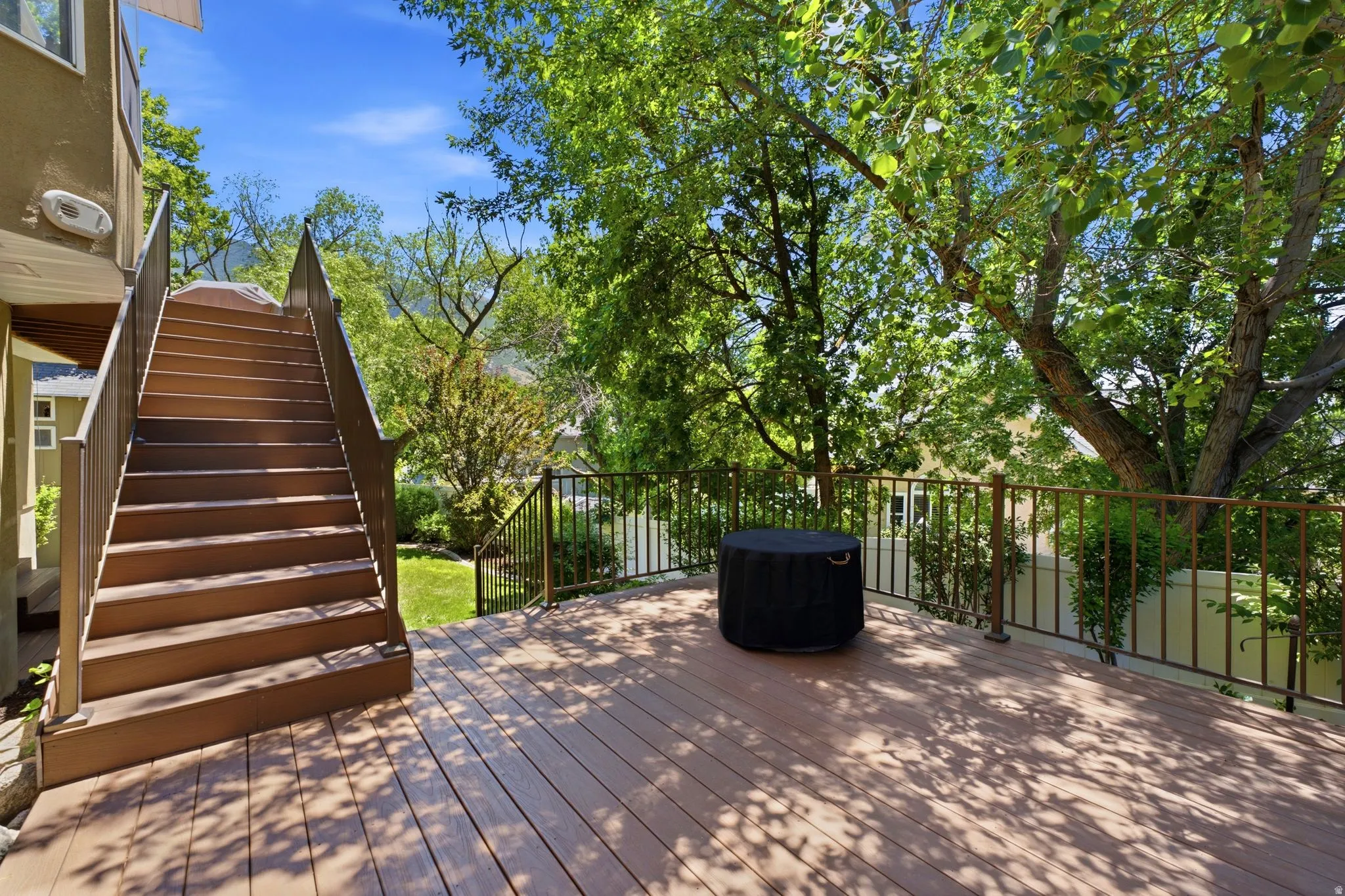 Spacious outdoor deck featuring wood-finish flooring and bronze-tone railings