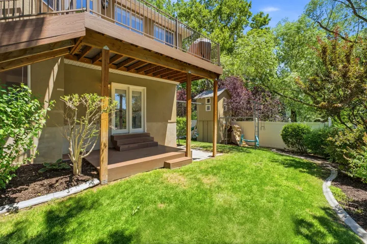 Expansive backyard featuring a manicured lawn and mature trees