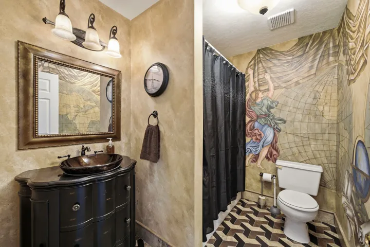 Powder room featuring a unique wall mural and a custom vanity with an oval vessel sink