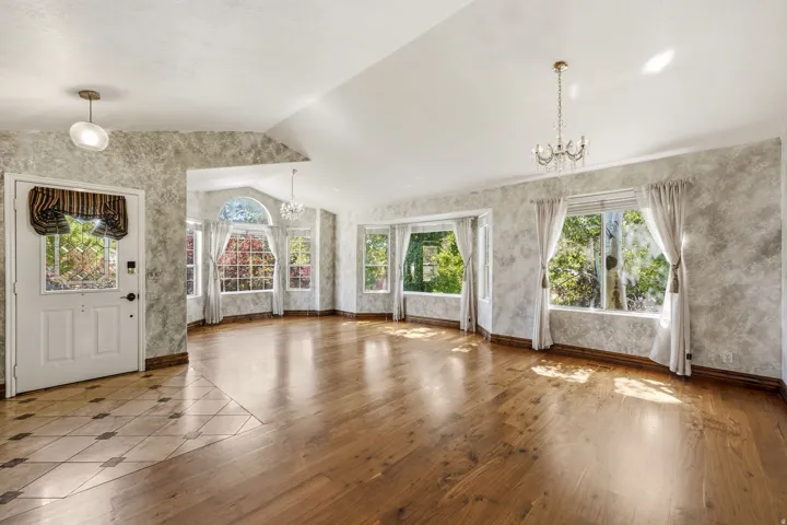 Expansive living area featuring wood-finish flooring and a vaulted ceiling