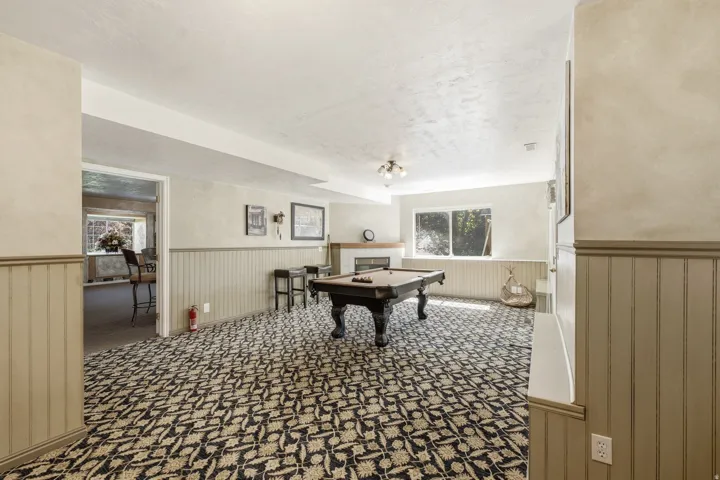 Spacious room featuring patterned carpet flooring and wainscoting