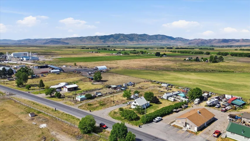 Expansive aerial perspective showcasing a rural landscape with agricultural fields and distant mountains