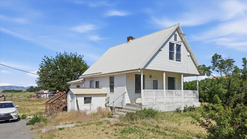 White siding exterior with a metal roof