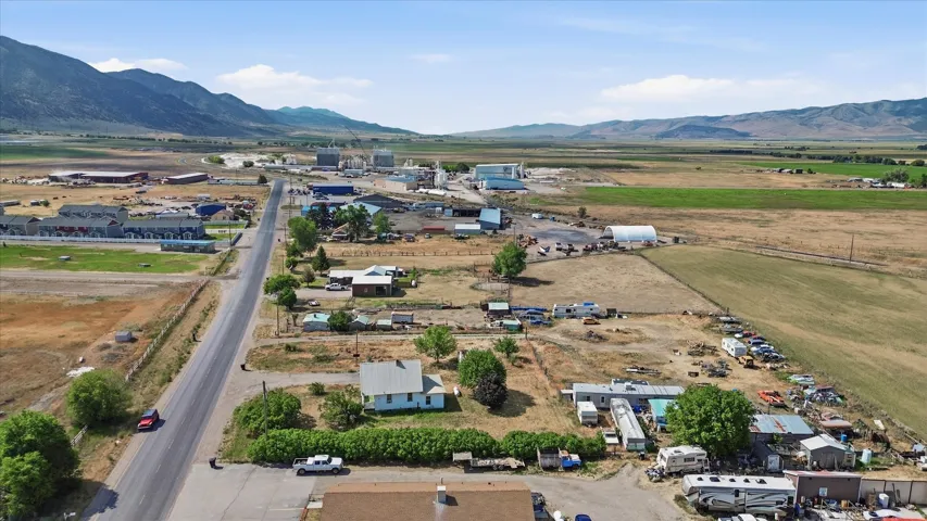 Aerial perspective of a rural landscape featuring agricultural fields and distant mountains